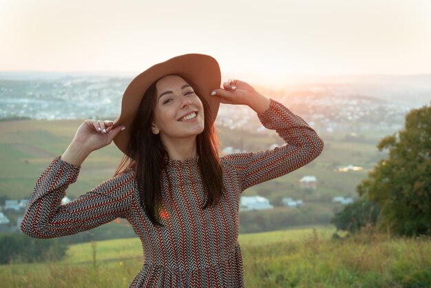 Portrait of a beautiful happy girl on a city background at sunset