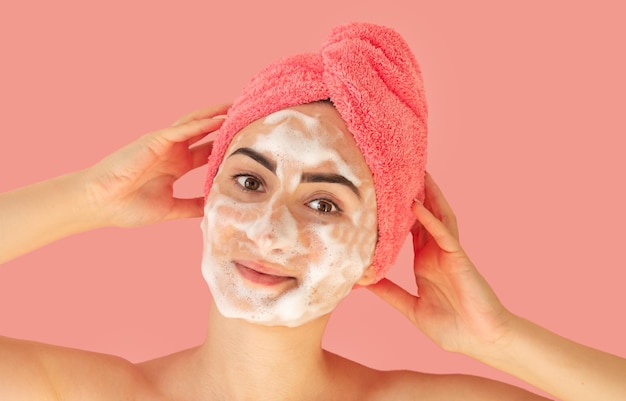 Portrait of beautiful happy woman applying cleansing foam for washing face. Skincare concept