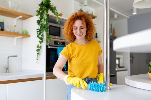 Portrait of a beautiful housewife cleaning dust with protective yellow gloves Woman happy cleaning concept