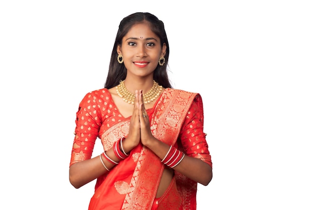 Portrait of a beautiful Indian girl in a greeting pose to Namaste hands Indian woman in traditional saree