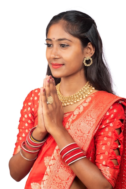 Portrait of a beautiful Indian girl in a greeting pose to Namaste hands Indian woman in traditional saree