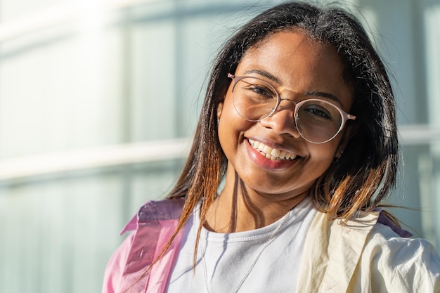 Portrait of a beautiful latin woman smiling and looking at camera outdoors in the student campus dur