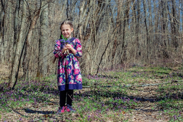 Portrait of a beautiful little girl with corydalis flowers