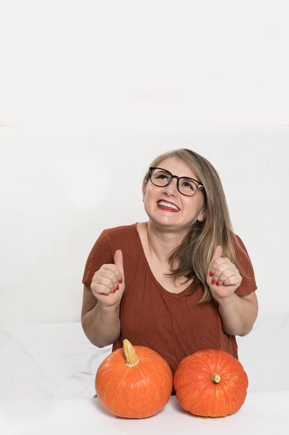 Portrait of beautiful middleaged blonde woman with pumpkin ready for halloween celebration mockup for postcard and invitation or advertisement