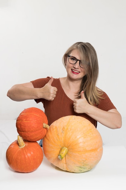 Portrait of beautiful middleaged blonde woman with pumpkin ready for halloween celebration mockup for postcard and invitation or advertisement