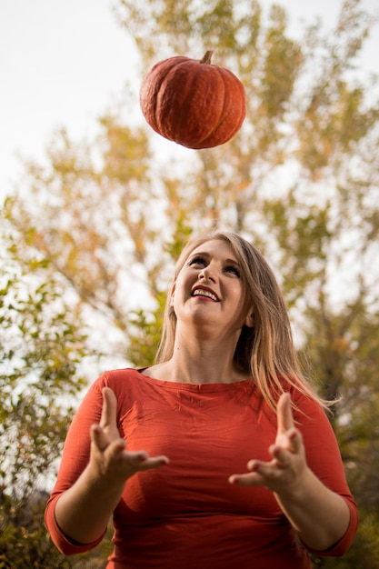 Portrait of beautiful middleaged blonde woman with pumpkin ready for halloween celebration mockup for postcard and invitation or advertisement