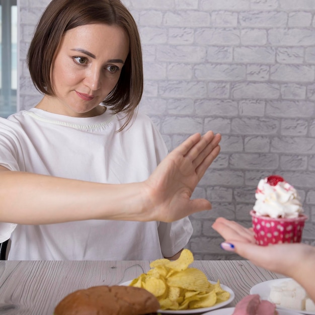 Portrait of a beautiful middleaged brunette woman promoting the rejection of unhealthy diet and harmful junk products