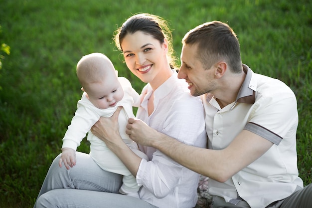 Portrait Beautiful Mother Father And Baby outdoors Happy family on a summer meadow