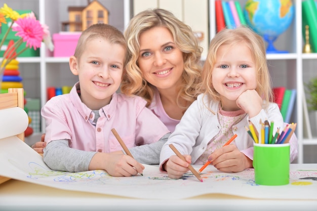 Portrait of a beautiful mother with daughter drawing with colorful pencils