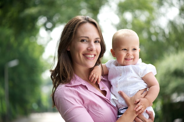 Portrait of a beautiful mother with smiling baby outdoors