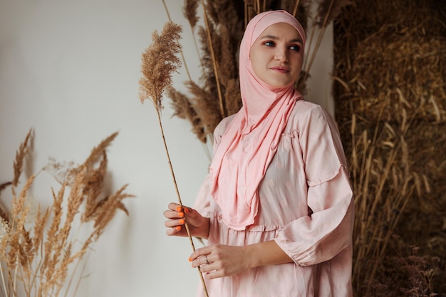 Portrait of beautiful muslim arabian woman wearing pink hijab side view