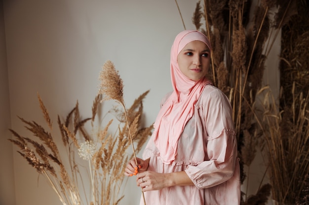 Portrait of beautiful muslim arabian woman wearing pink hijab side view