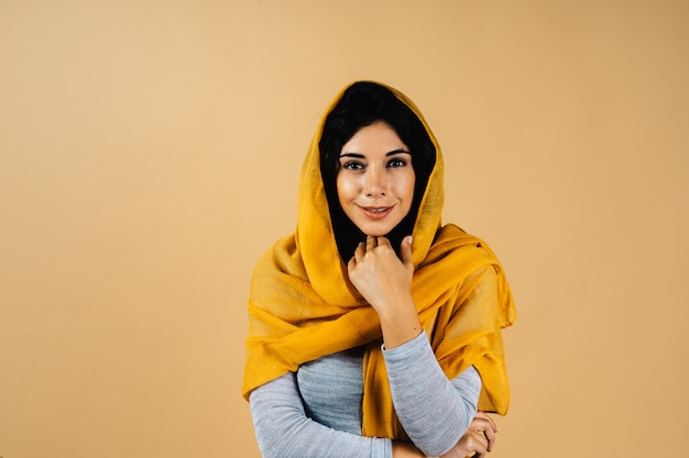 portrait of beautiful muslim woman against orange backgroun