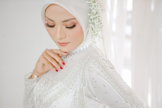 Portrait of beautiful muslim woman wearing white wedding dress