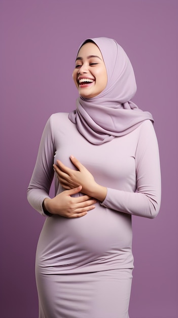 Portrait of beautiful pregnant Muslim woman holds hands on belly on purple background