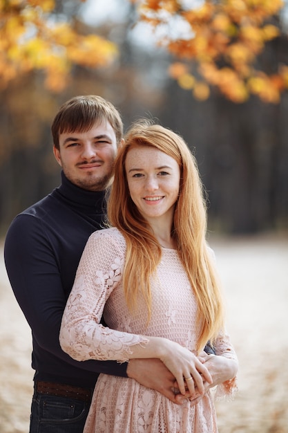 Portrait of a beautiful red-haired girl with her beloved husband with a beard