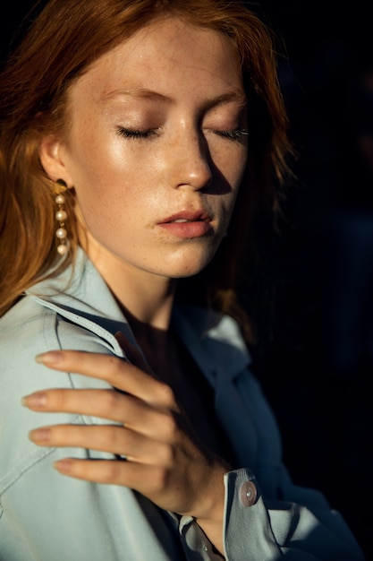 Portrait of a beautiful redhead woman in a blue shirt