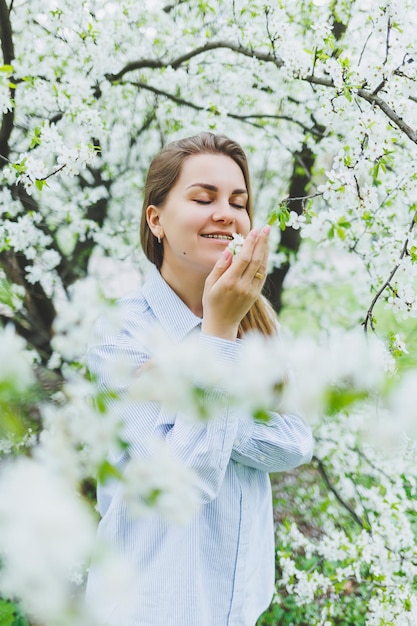 Portrait of beautiful romantic lady in apple trees blossoms