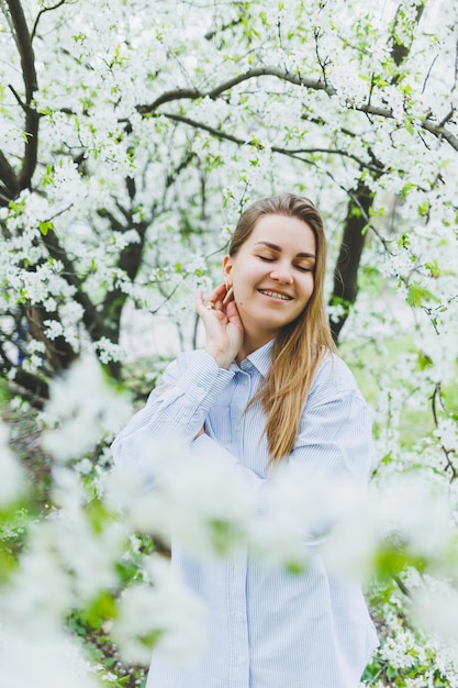 Portrait of beautiful romantic lady in apple trees blossoms