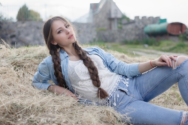 Portrait of a beautiful romantic young woman in the countryside at sunset. attractive girl in denim clothes