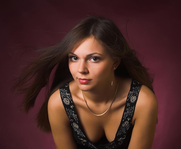 Portrait of a beautiful sexy brunette girl with wind in the hair