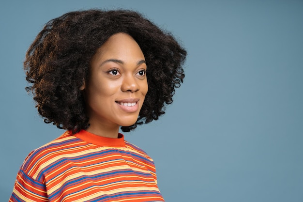 Portrait of beautiful smiling African American girl wearing stylish t shirt looking away