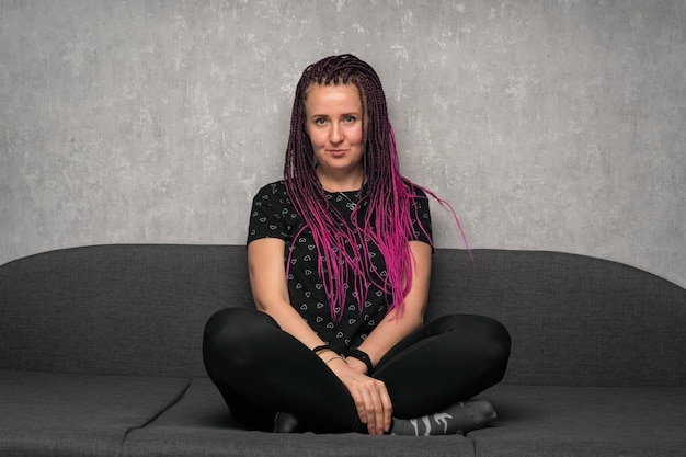 Portrait beautiful smiling caucasian woman with color dreads against grey background Middleaged woman hipster style