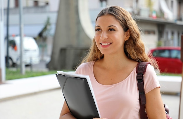 Portrait of beautiful smiling university female student goes back to school