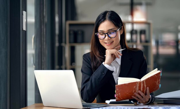 Portrait of beautiful smiling young entrepreneur businesswoman with glasses working in modern work station