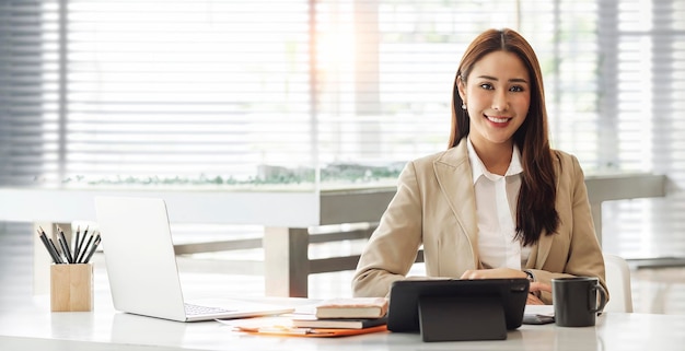 Portrait of beautiful smiling young entrepreneur businesswoman working in modern work station Smiling to the camera