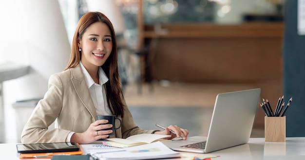 Portrait of beautiful smiling young entrepreneur businesswoman working in at office smiling and looking at camera