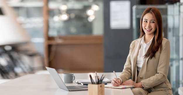 Portrait of beautiful smiling young entrepreneur businesswoman working in at office smiling and looking at camera