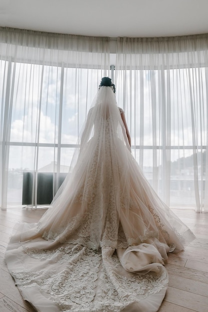 Portrait of a beautiful stylish bride with an elegant dress view from the back Wedding people fashion and beauty concept bride in wedding dress Back view