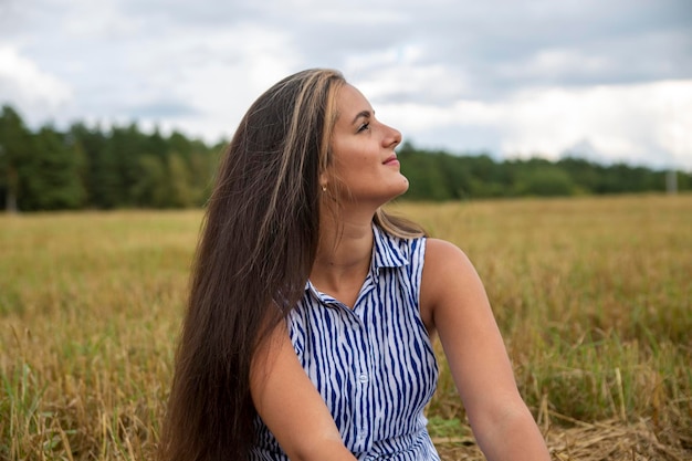 Portrait of a beautiful swarthy caucasian young woman on a background of a field nature smiling happy young adult