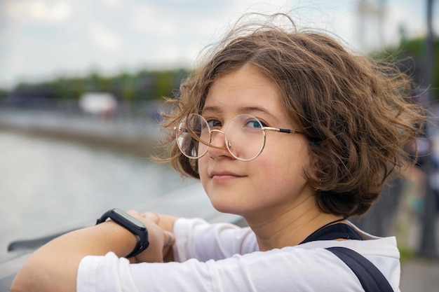 Portrait of beautiful teenage girl with curly hair in fashionable glasses