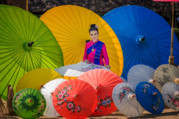 Portrait of Beautiful Thai Women in Lanna traditional costume,  Handmade umbrella making vintage style in Chiang mai, Thailand