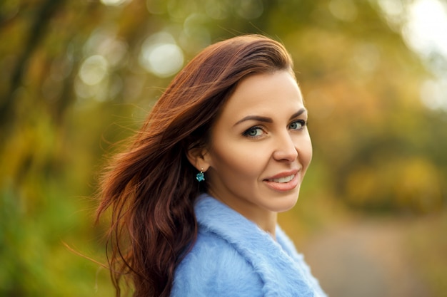 Portrait of beautiful woman in autumn park