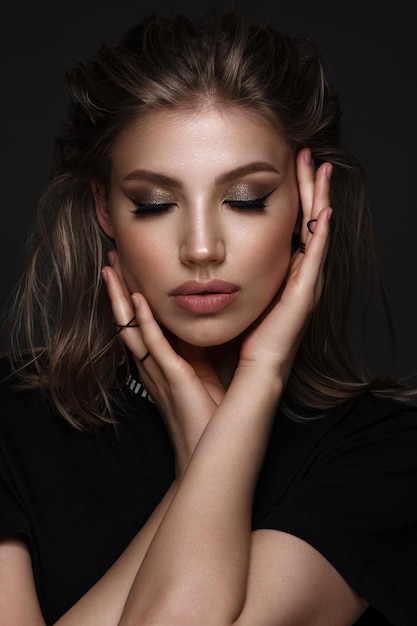 Portrait of a beautiful woman in a black dress with creative makeup in a fashion style beauty face