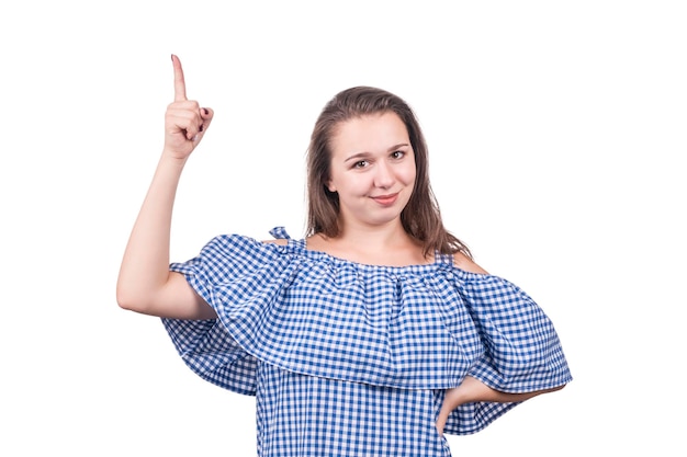 Portrait of a beautiful woman in a checkered dress with forefinger up, isolated on a white background