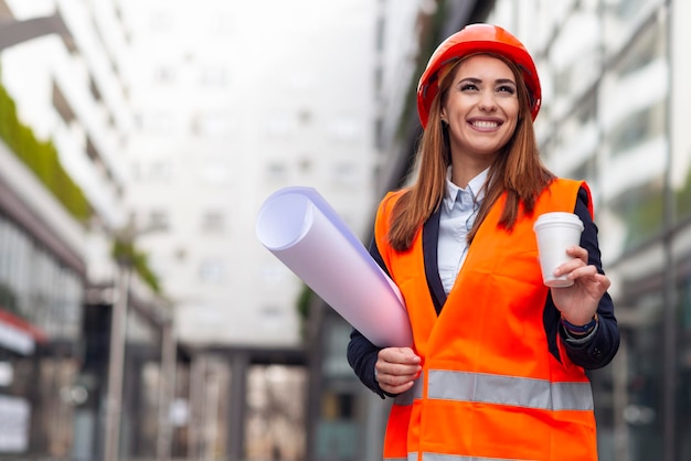 Portrait of beautiful woman engineer holding cup of coffee