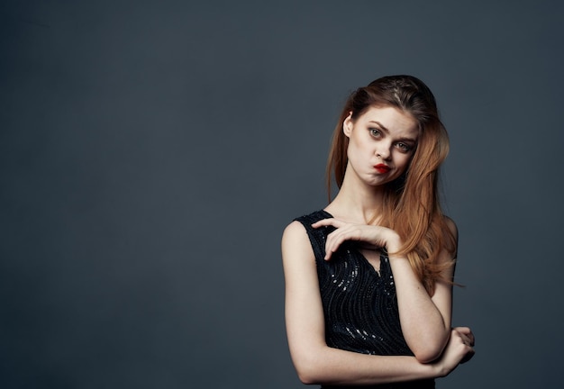 Portrait of a beautiful woman gesturing with her hands gray background cropped view closeup