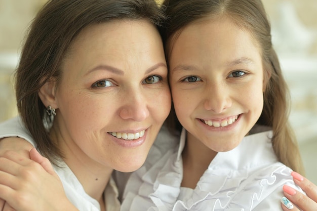 Portrait of beautiful woman and girl posing at home