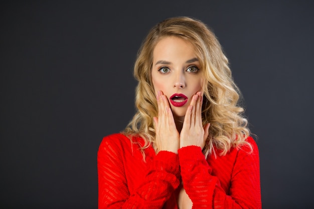 portrait of a beautiful woman girl with makeup and hairdo on a black background with a frightened face