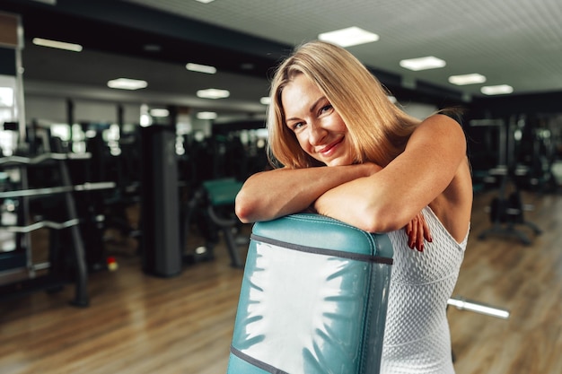 Portrait of a beautiful woman in good shape posing in sport gym