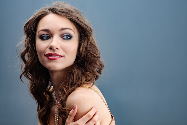 Portrait of a beautiful woman hugging herself by the shoulders looking back