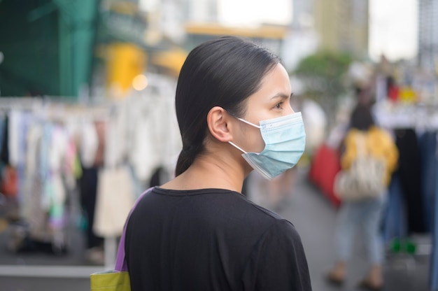 Portrait of beautiful woman is wearing face mask in shopping center