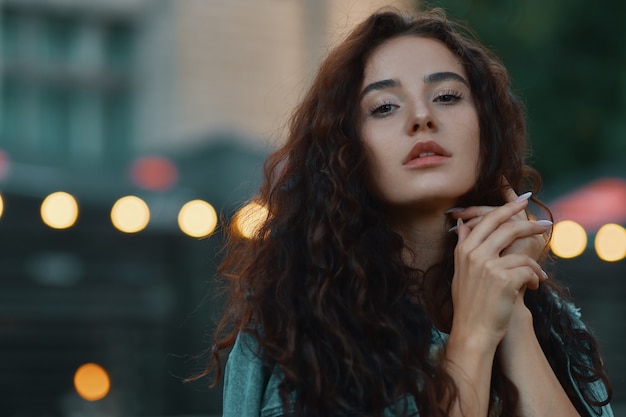 Portrait of beautiful woman posing over blurred lights