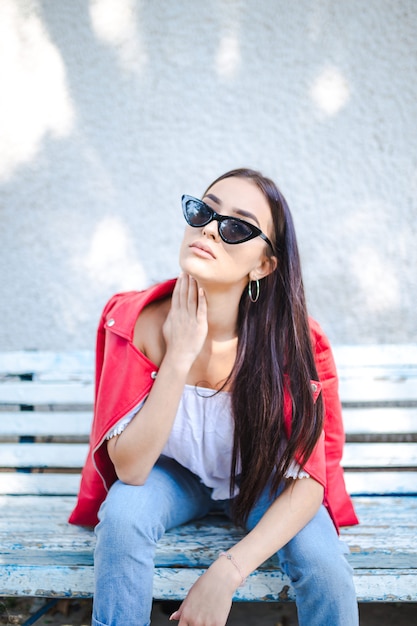 Portrait of beautiful woman sitting on the bench in park