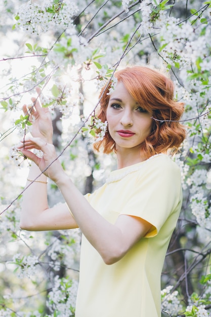 Portrait of beautiful woman in spring blooming garden