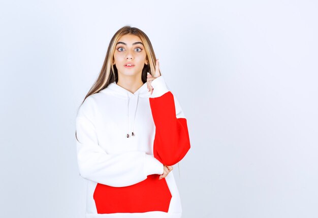 Portrait of a beautiful woman in warm hoodie standing and looking at camera